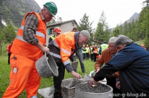 Unter fachkundiger Anleitung eines RhB-Mitarbeiter setzen Hans Amacker, Direktor RhB, Heinz Dudli, Verwaltungsrat RhB, und Ladina Meyer, Gemeindepraesidentin Bever, den Messbolzen. Impression vom Spatenstich fuer den Albulatunnel II der Rhaetischen Bahn am 25. Juni 2014 in Preda - Quelle: RhB / swiss-image.ch [b]